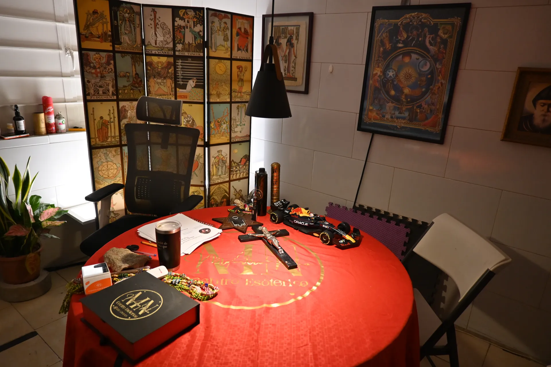 Mesa de consultas con tarot, crucifijo y artículos ceremoniales MN