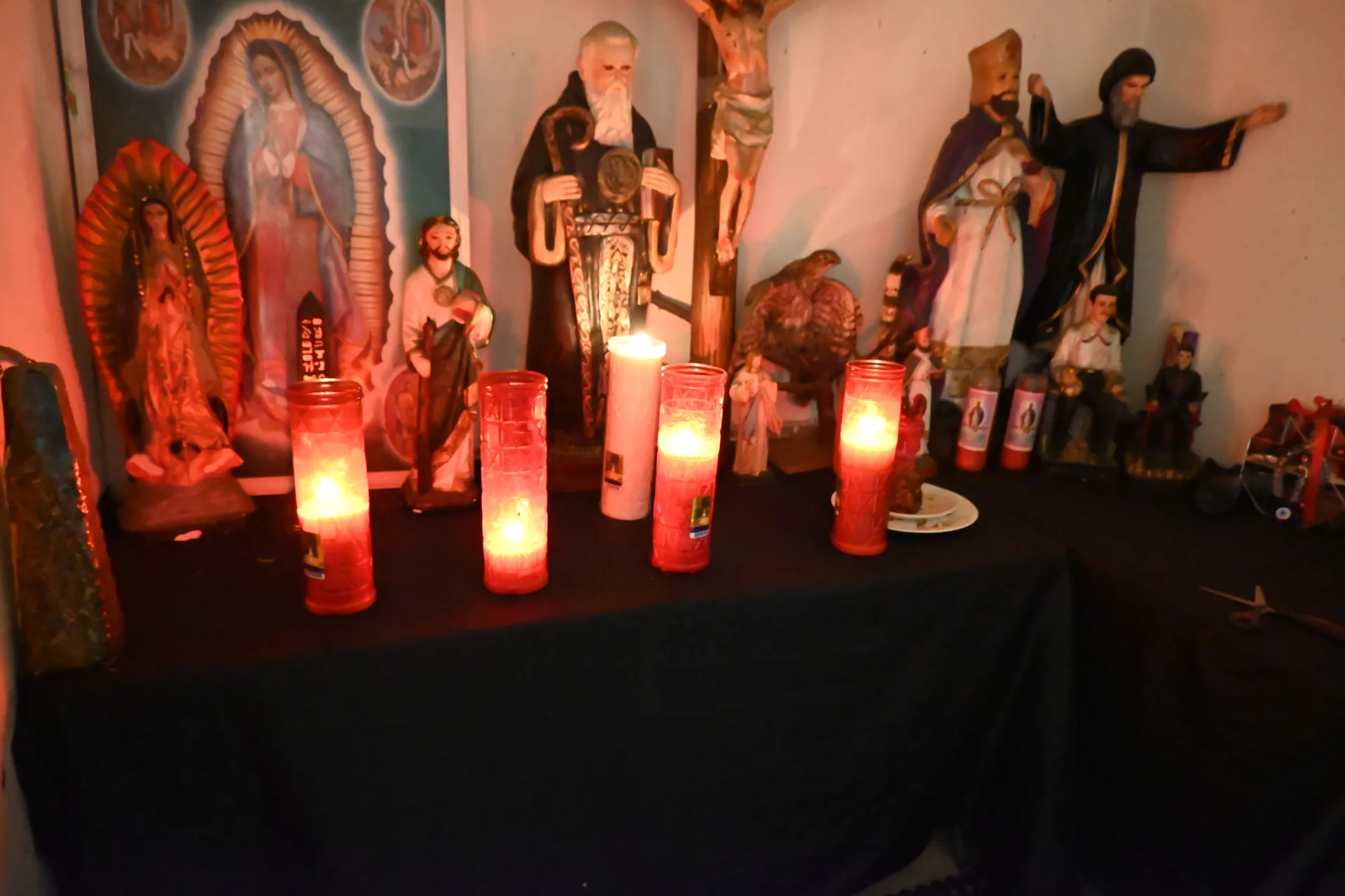 Altar de velas con Virgen de Guadalupe y santos en ambiente místico